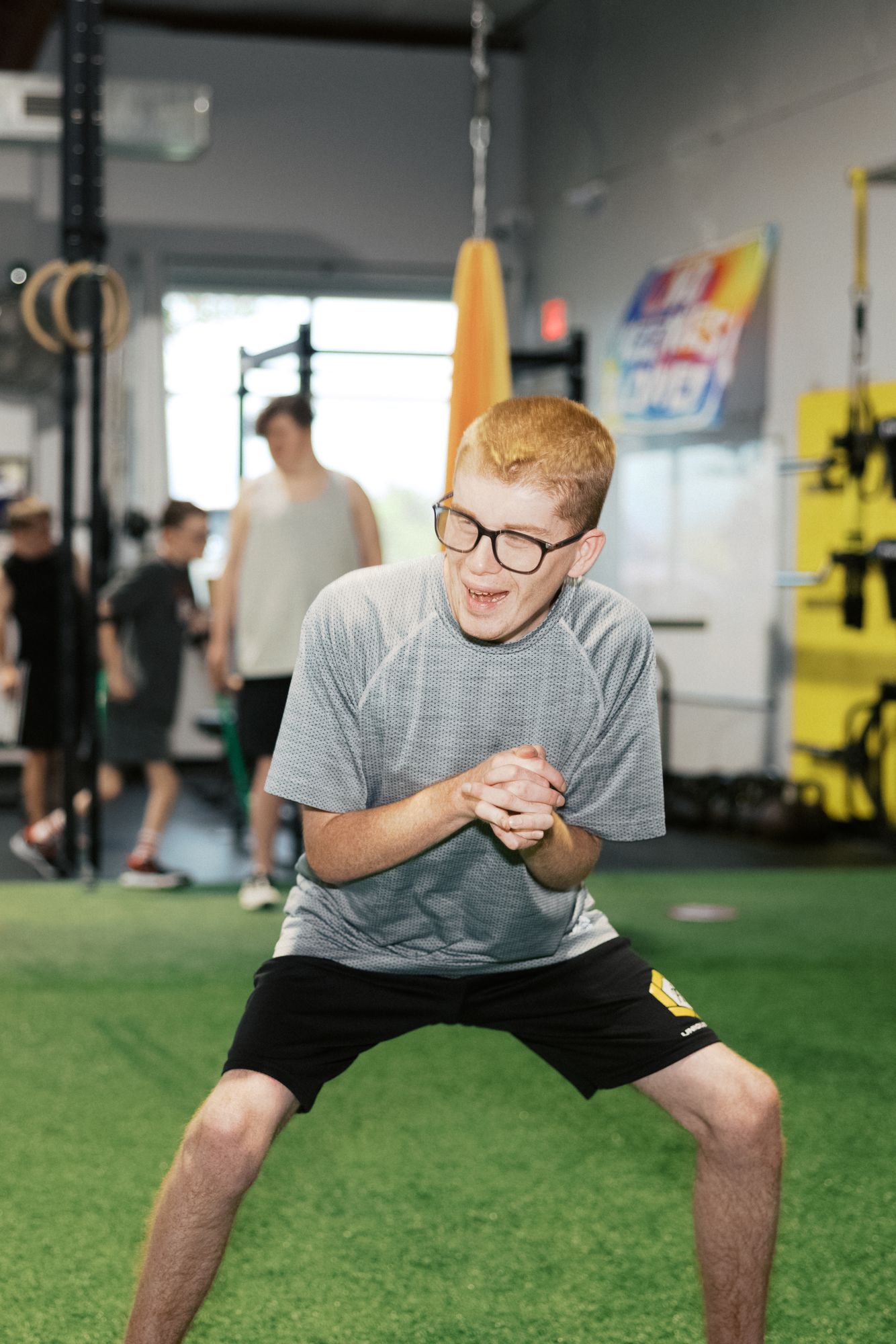 A young athlete holding his squat on the turf